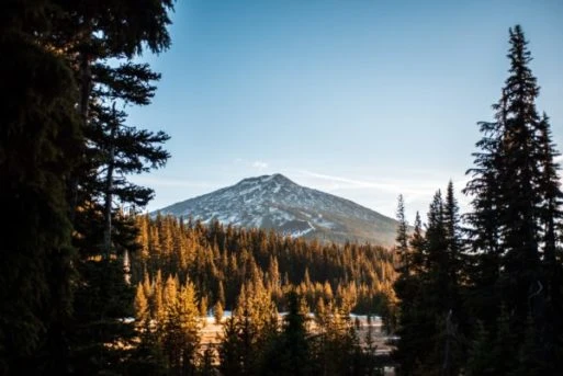 Mount Hood at sunrise, a majestic snow-capped peak surrounded by a serene landscape.